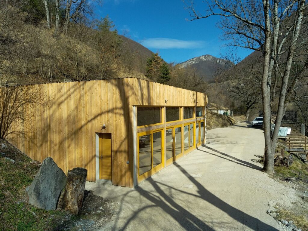 Local en maçonnerie avec bardage bois et cour en graviers, réalisé par Joubert Pinet