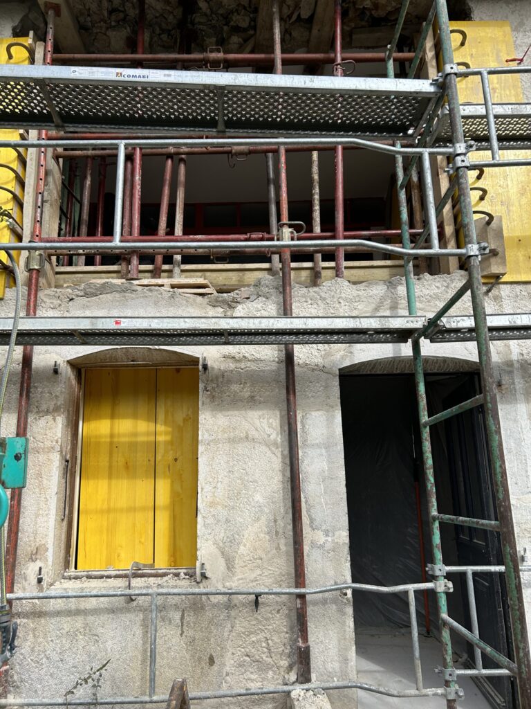 Façade en pierre étayée pendant la création d'ouvertures en sous-oeuvre