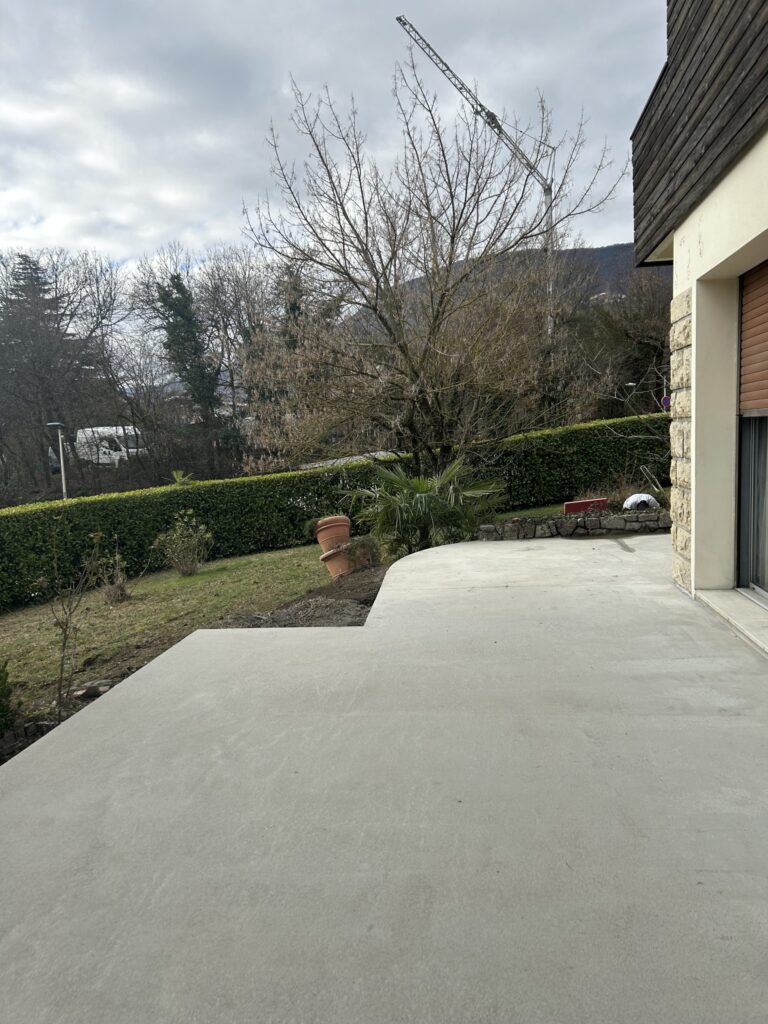 Terrasse en béton réalisée en épousant le terrain et la végétation existante